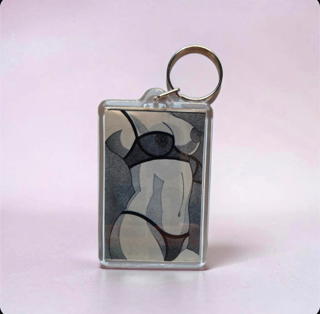 Keychain featuring a stylized illustration of a female body wearing black lingerie.