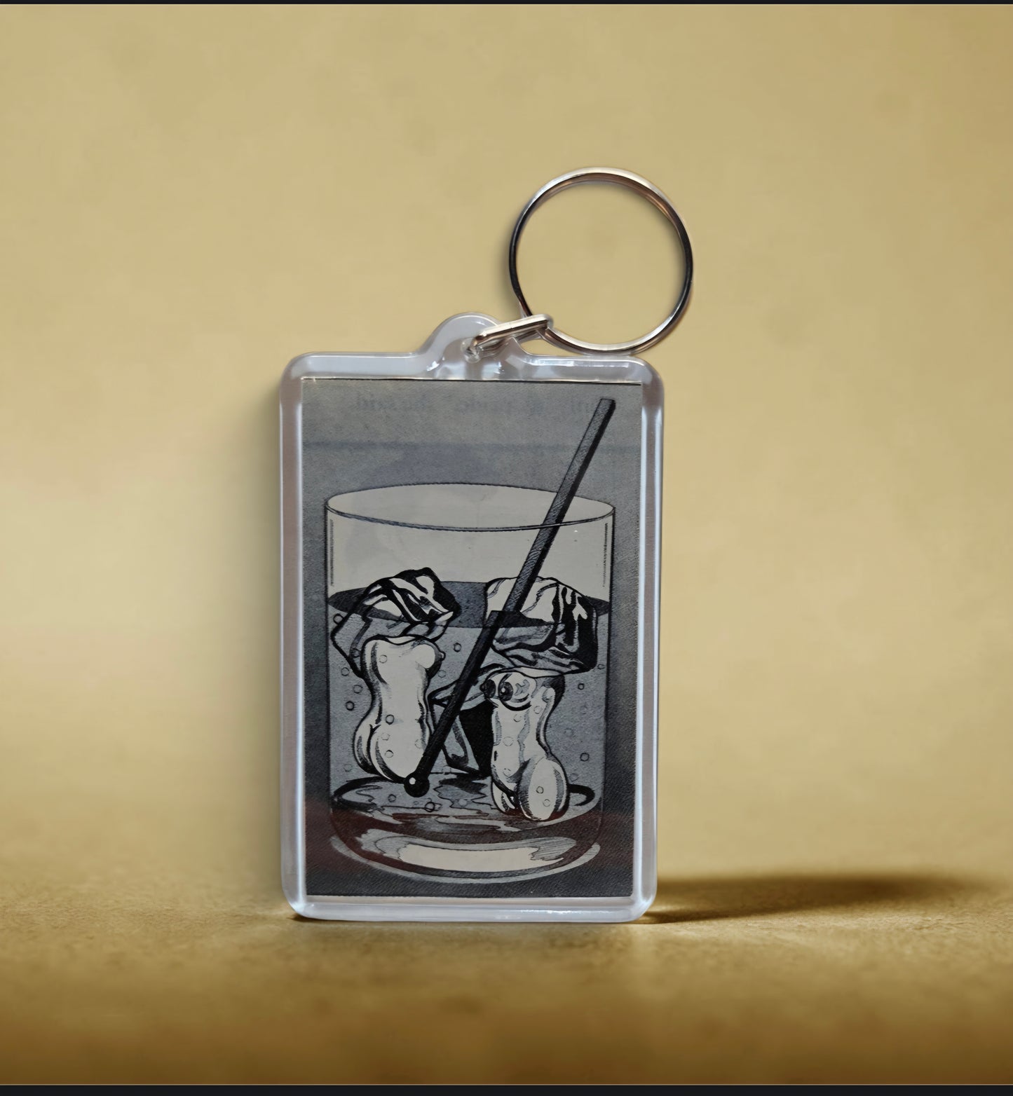 Keychain featuring an illustration of an Old Fashioned cocktail with a straw and ice cubes.