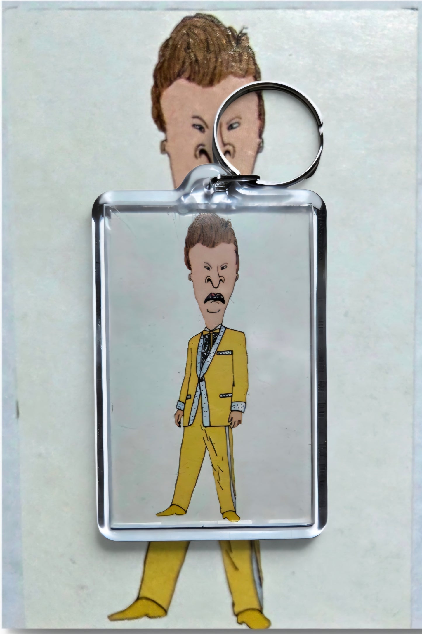 Key chain featuring a drawing of Beavis from Beavis and Butt-Head styled in a yellow suit